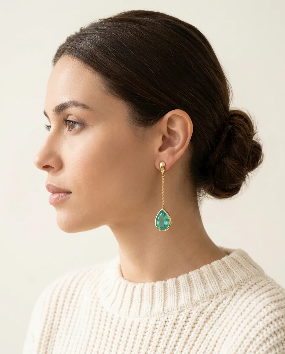 Perfil de mujer con pendiente de oro y gota verde agua